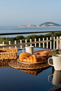 una mesa con un plato de pan y tazas de café en La Vista Formia B&B, en Formia