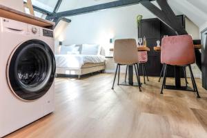 a room with a washing machine and two chairs at Romantic 35m2 City Center Suite in Delft