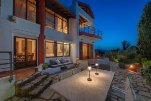 a house with a patio with a table and chairs at Avista Villa in Vourvourou