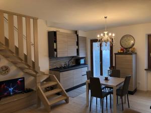 cocina y comedor con mesa y escalera en Stanza privata con bagno Contrada Covile, en Bosco Chiesanuova