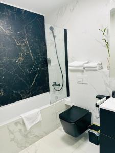 e bagno con doccia e servizi igienici neri. di Bel Dom - The Central, spacious 2 rooms luxury apartment a Cluj-Napoca