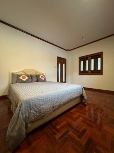 sypialnia z dużym łóżkiem i drewnianą podłogą w obiekcie RT House w mieście Chiang Mai
