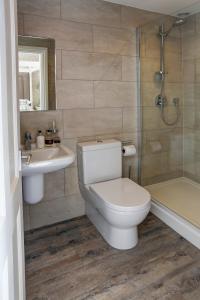 La salle de bains est pourvue de toilettes, d'un lavabo et d'une douche. dans l'établissement Falcon Manor Hotel, à Settle