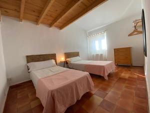 1 dormitorio con 2 camas y techo de madera en Finca es Born - vistas panorámicas en Esporles