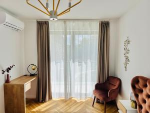 Zimmer mit einem Fenster, einem Stuhl und einem Schreibtisch. in der Unterkunft Bel Dom - The Central, spacious 2 rooms luxury apartment in Cluj-Napoca