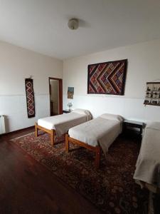 Habitación con 2 camas y alfombra. en La Cara Oculta de Salta, bed and breakfast en Salta