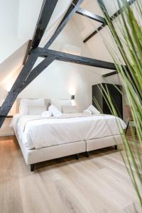 um quarto com uma grande cama branca num quarto em Romantic 35m2 City Center Suite em Delft