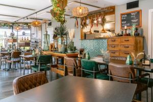 een restaurant met tafels en stoelen en een schoolbord bij B&B Brasserie Villare in Wijlre