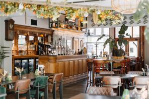 a restaurant with tables and chairs and a bar at B&B Brasserie Villare in Wijlre