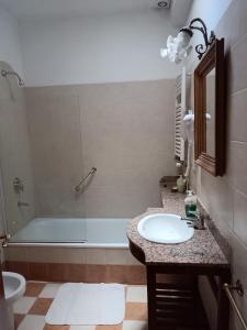 y baño con bañera, lavamanos y ducha. en La Cara Oculta de Salta, bed and breakfast en Salta