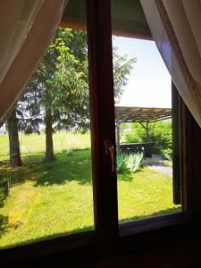 einen Blick aus dem Fenster eines Gartens in der Unterkunft MERIKOTKA - a cozy wooden cottage, sLOVEnia in Braslovče