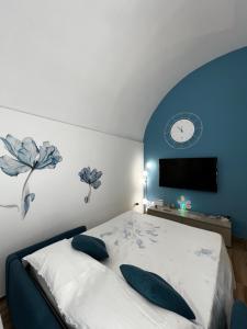 a bedroom with a bed and a clock on the wall at Dimora Nonno Ciccio in Polignano a Mare