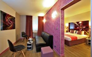 リモージュにあるThe Originals City - Hôtel Saint-Martial, Limoges Centreのベッドとソファ付きのホテルルーム
