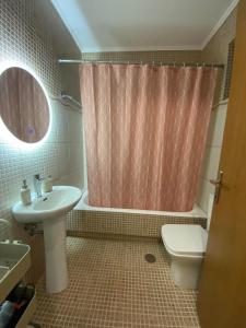 a bathroom with a sink toilet and a shower curtain at Konstantino's Apartment in Monemvasia