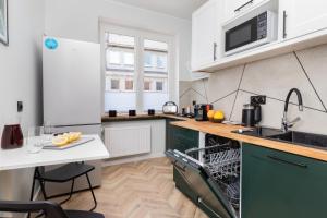 a kitchen with green cabinets and a white counter top at Old Town Apartment Garncarska by Renters in Gdańsk
