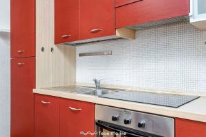 - une cuisine avec des placards rouges et un évier dans l'établissement Stop, à La Spezia