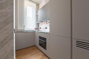 una cucina con armadietti bianchi e una finestra di Palazzo Signoria Luxury Apartments 10- Giuditta a Firenze