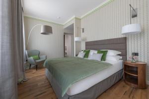 una camera da letto con un grande letto con cuscini verdi e bianchi di Palazzo Signoria Luxury Apartments 10- Giuditta a Firenze