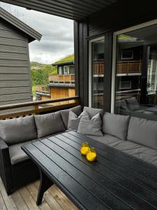 a couch and a table on a screened in porch at Fin leilighet på Geilotunet leies ut in Geilo