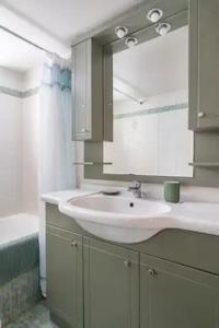 a bathroom with a white sink and a mirror at Athens Riviera modern apartment in Piraeus