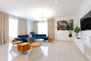 een grote woonkamer met een blauwe bank en stoelen bij Gallery suites and Apartments in Accra