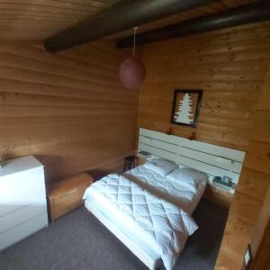 a bedroom with a bed in a log cabin at chalet de la Cercenée in Gérardmer