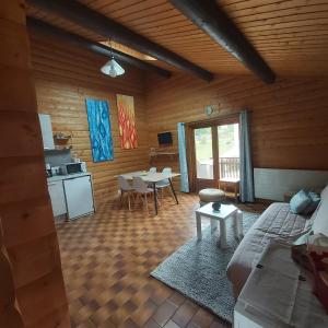 a living room with a couch and a table and a kitchen at chalet de la Cercenée in Gérardmer
