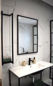Baño blanco con lavabo y espejo en SeaView Apartment Megas Limnionas en Chios