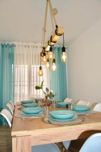 a dining room table with blue plates and lights at Casas Rurales Los Teatinos in Casas de los Teatinos