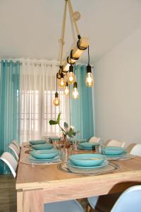 una mesa de comedor con platos azules y luces en Casa Rural Los Teatinos, en Casas de los Teatinos