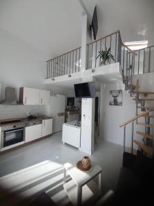 una grande cucina bianca con scala a chiocciola in una casa di Rhön Apartments a Frankenheim