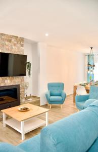 sala de estar con sofá azul y chimenea en Casa Rural Los Teatinos, en Casas de los Teatinos
