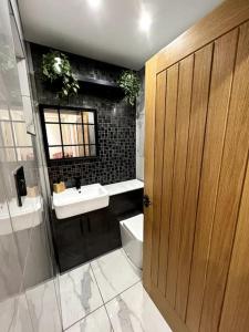 a bathroom with a sink and a toilet and a mirror at Large 4 bedroom house, electric gated driveway. in Bidston +35 photos