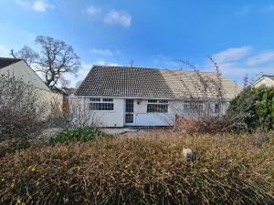 a white house with a roof in a yard at 2-Bed House Bungalow in Bristol in Bristol