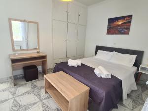 a bedroom with a bed with a mirror and a desk at Villa Elia Perigiali Lefkada in Nydri