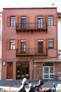 un edificio rosa con moto parcheggiate di fronte di Luminous a House of Luxury a Chania