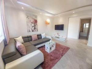 uma sala de estar com um sofá e uma televisão em Luxury two-bedroom apartment by the sea U KaLu em Postira