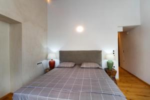 a bedroom with a bed with two lamps and two vases at Luminous Luxury Apartment in Chania