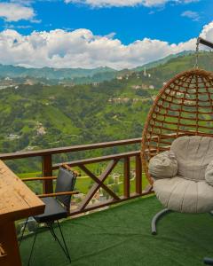 a swing and two chairs on a balcony with a view at Keyfi Teras Bungalov in Rize