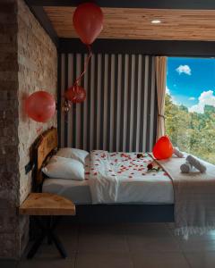 a bedroom with a bed with balloons and a window at Keyfi Teras Bungalov in Rize