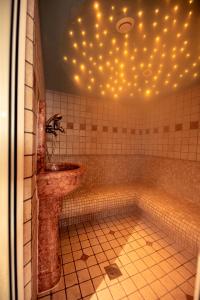 坎波圖雷斯的住宿－Roanerhof，浴室配有水槽和带灯的浴缸。