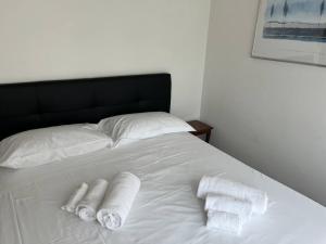 un letto bianco con due asciugamani arrotolati di La Casa Del Conte a San Salvatore
