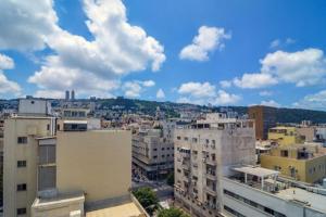 a view of a city with buildings and clouds at Diana Hotel in Haifa