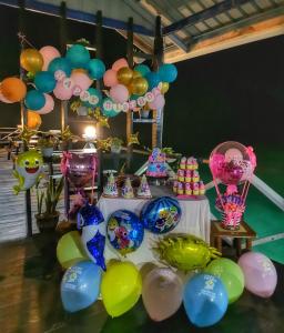 a table with balloons and a bunch of other balloons at Maglami-lami Water House in Semporna