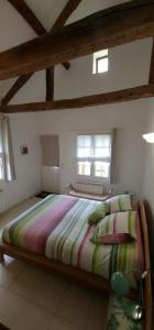 a bedroom with a large bed in a room with windows at Honfleur à deux in Honfleur