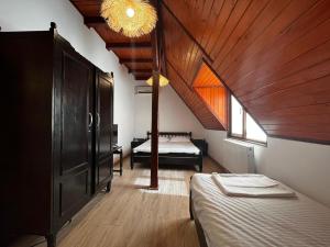a room with two beds and a ceiling with a window at La Conac in Nufăru