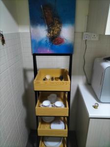 a bathroom with a shelf with three toilets and a painting at Upper Sanctuary in Kuching