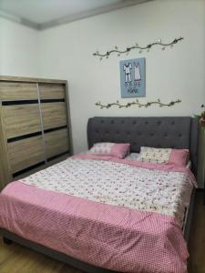 a bedroom with a bed with pink and white sheets at Upper Sanctuary in Kuching