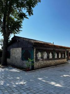 a stone building with a tree in front of it at La Conac in Nufăru
