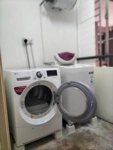a washing machine and a toilet in a room at Upper Sanctuary in Kuching